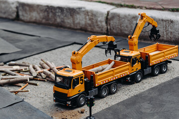 radio-controlled toy on toy construction site, radio-controlled log loader, entertainment for children