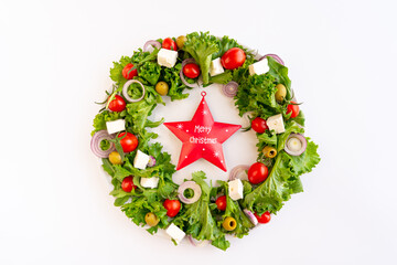 Close-up of the Christmas wreath salad with vegetables and feta cheese on the dark background. Selective focus