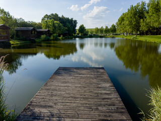 Obraz premium Discover the perfect fishing spot on our serene lake. Enjoy tranquil surroundings, clear waters, and the thrill of the catch. Ideal for a relaxing day in nature with friends and family.
