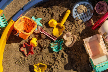 Children's sandbox with toys. Children's plastic shovels, bucket and sand molds for playing in the...