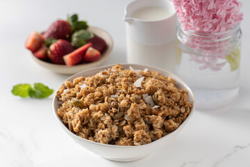 Crispy homemade granola with sliced almonds in a bowl with strawberries. Healthy eating