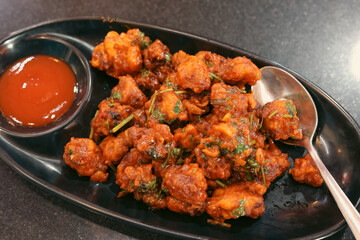 Gobi Manchurian dry, Gobi 65, chilly gobi or cauliflower fry. Popular street food of India made of cauliflower florets Mumbai Mysore, Karnataka India