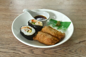 Inari Sushi Japanese food made from rice wrapped by fried tofu and maki rice stuffed sweet egg roll seaweed with wasabi dipping soy sauce on plate 