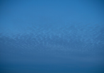 High stationary clouds and lower clouds, moving across the night sky,
