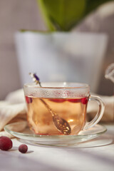 Fruits and berries tea. Glass teapot and cup on the table