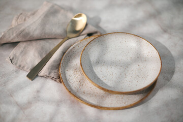 Empty plate, cutlery and a napkin on a light background. Table setting on table. Top view.