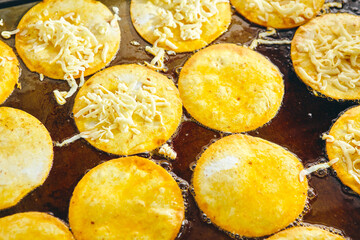 Frying tacos tortillas with cheese on griddle in professional kitchen in restaurant. Mexican cuisine, Latin American fast food