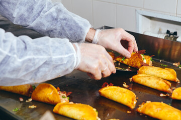 Frying tacos tortillas with cheese, onion, herbs and meat on griddle in professional kitchen in restaurant. Mexican cuisine, Latin American fast food
