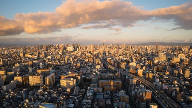 aerial view timelapse of osaka city center slyline from day to night,high view time lapse of downtown cityscape at sunset,umeda business district in the background
