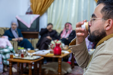 young male holding cup of coffee with family gathering time indoors, enjoy time with family