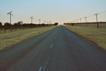 Fototapeta premium A tar road with telephone poles still visible on the sides,in South,Africa.