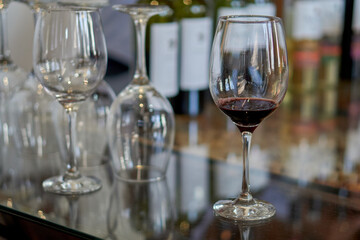 several glasses of wine on a glass table in a wine cellar at a wine tasting. Selective focus