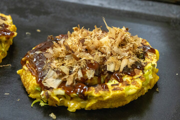 Okonomiyaki cooks on the hot pan