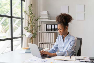 Female Entrepreneur. Cheerful African American Businesswoman Working On document and Laptop In Modern Office. Empty Space