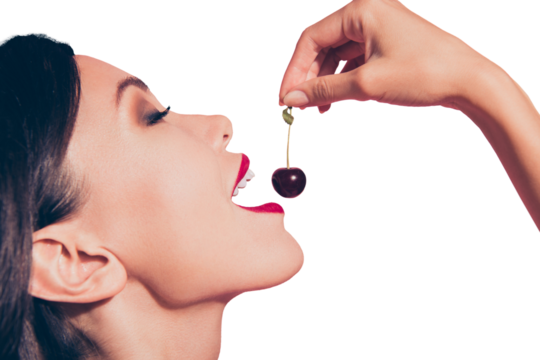 Close-up cropped profile side view portrait of nice cute sweet lovely attractive adorable charming girl red lips holding in hand cherry closed eyes feeding isolated over pink background - Powered by Adobe