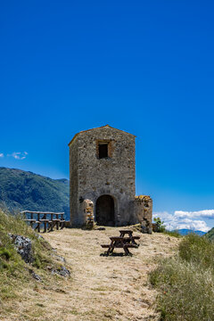 The small hermitage of San Salvatore, on Mount Antuni, Lake Turano, in the village of Castel di Tora, Rieti, Lazio, Italy. The little church surrounded by green mountains. Blue sky in summer.