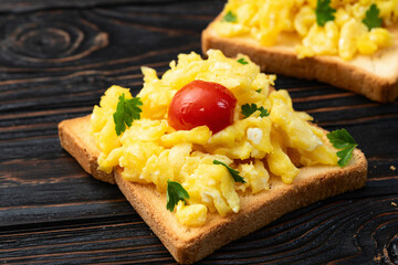 Healthy vegetarian breakfast . Scrambled eggs toast with cherry tomatoes and parsley