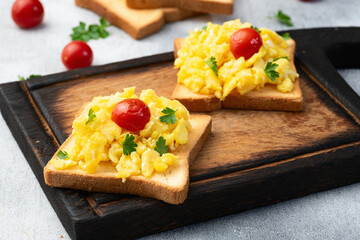 Healthy vegetarian breakfast . Scrambled eggs toast with cherry tomatoes and parsley