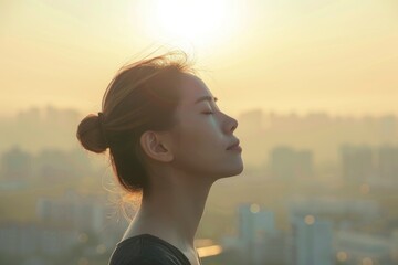 Profile of a woman breathing deeply fresh air with a city in the background