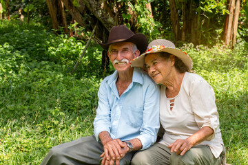 Lifestyle: smiling elderly married couple sitting outdoors
