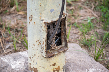 Light pole with dangerous cables exposed and in poor condition. Public electrical installation in poor condition.