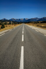 Straight road from La Quillane to Les Angles (France). At the background, some mountains from Pyrenees Orientales