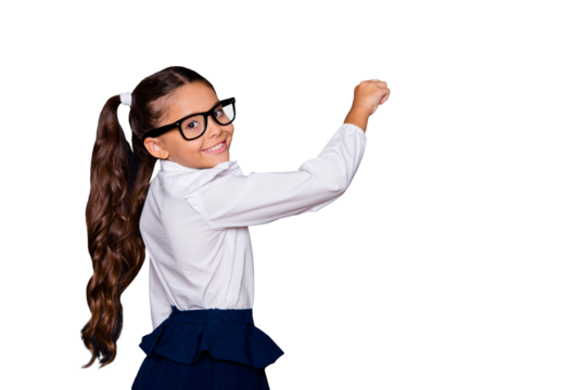 Portrait of nice genius cheerful adorable lovely small little girl with curly pigtails in white formal blouse shirt, blue skirt, writing on blackboard. Isolated over black background