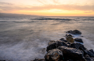 Naklejka premium waves in long exposure at sunset on the Mediterranean coast