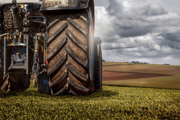 traktor von hinten auf einem feld bei der ernte 