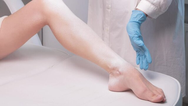 Elos epilation hair removal procedure on a woman&rsquo;s body. Beautician doing laser rejuvenation on the lower leg in a beauty salon. Removing unwanted body hair. Hardware ipl cosmetology