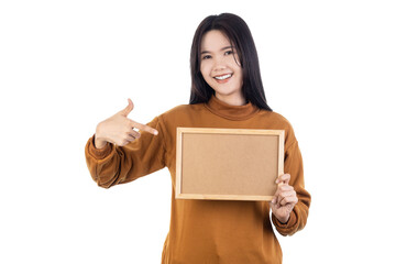 Asian young woman holding blank wooden frame and pointing at it isolated on white background with clipping path.