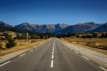 Straight road from La Quillane to Les Angles (France). At the background, some mountains from Pyrenees Orientales