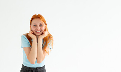 Headshot of pleased high spirit pretty female model, has warm pleasant smile, keeps hands under chin, wears blue t-shirt, isolated over white background. Happiness concept