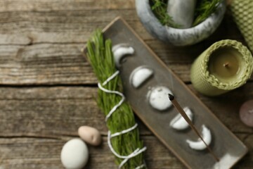 Flat lay composition with incense stick smoldering in holder on wooden table