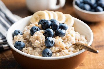 Breakfast with oatmeal, blueberries, and bananas in a charming rustic setting, closeup view