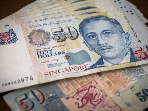 Singapore dollar money background. Several Close-up 50 Singapore dollars currency banknote bills were unfolded. Business finance and banking concept. - Powered by Adobe