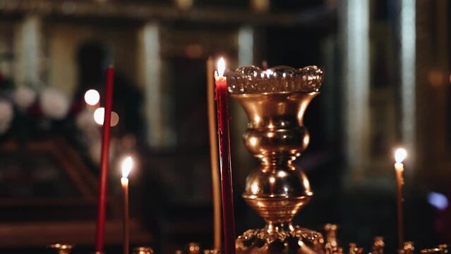 The Easter Liturgy is held in the Orthodox church. The camera takes a close-up of candles