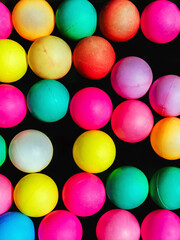 Top view of many colorful plastic balls on water. View of colored sponge balls. Many colorful balls as background. Lots of colorful balls for children to play in the water park. Toy pool for kids.