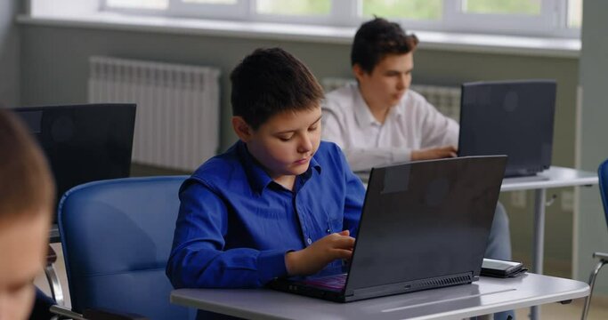 School Students Working With Laptops In Modern Computer-Based Classroom, Portrait Of Preteen Boy