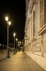 Row of streetlights illuminating a building at night in Madrid, Spain, 2024-07-01