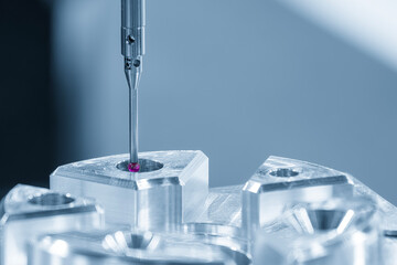 The  CMM probe measuring the  aluminum automotive parts.