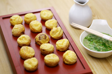 Homemade Akashiyaki (the origin of takoyaki) is round dumplings made of an egg-rich batter and octopus. Dipped into dashi before eating. Japanese food.