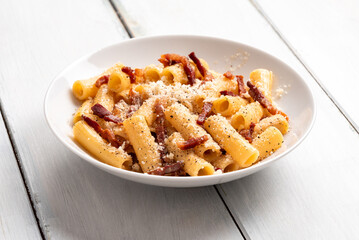 Piatto di deliziosa pasta alla gricia, ricetta romana di rigatoni con pecorino, guanciale e pepe nero, cibo italiano, gastronomia europea 