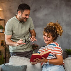 girlfriend sit on sofa read book and discuss whit her boyfriend