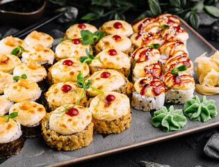 Delicious assorted sushi platter on dark stone background