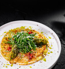 Gourmet asparagus omelette on dark background