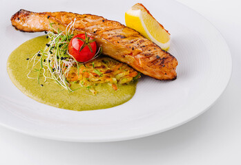 Gourmet grilled salmon on a bed of green sauce