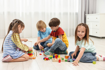 Naklejka premium Group of children playing together on floor indoors
