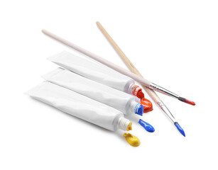 Tubes with colorful paints and brushes isolated on white