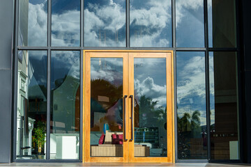 Glass door entrance to a large apartment hotel, the material is wood and steel, beautifully...